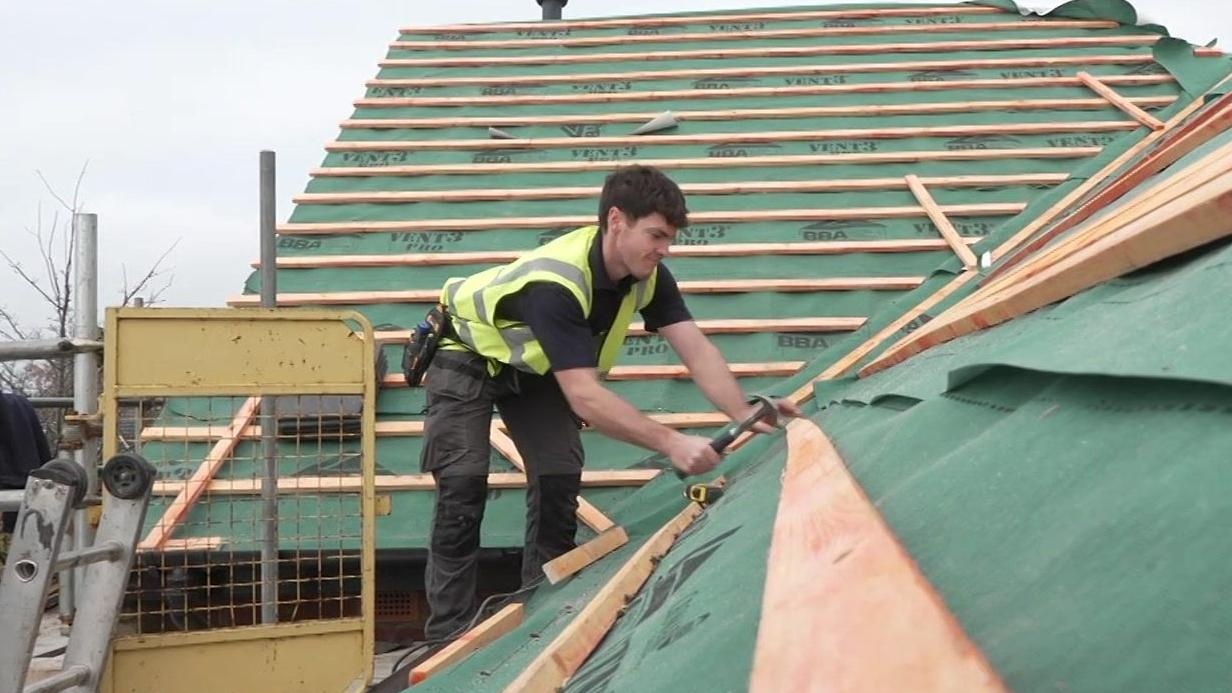 Professional roofer working on tiles